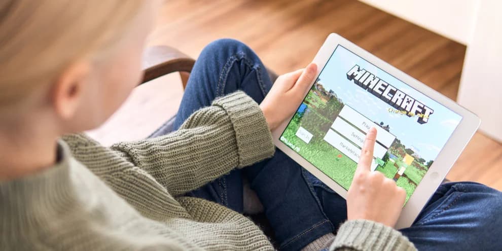 Minecraft būrelis vaikams — vaikas kuria Minecraft Education aplinkoje su planšete
